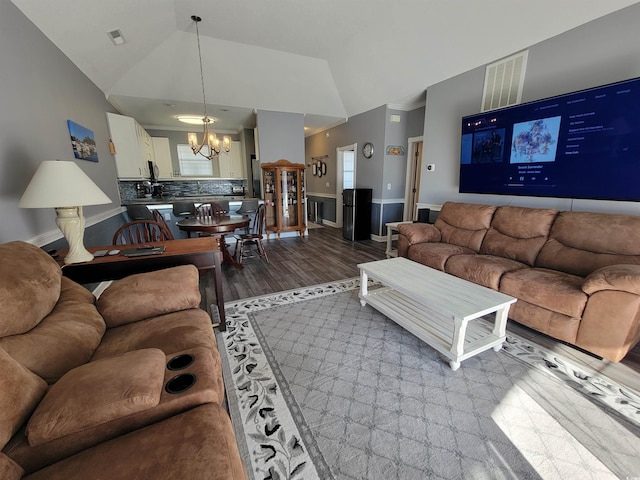 living room with wood-type flooring, lofted ceiling, and a notable chandelier