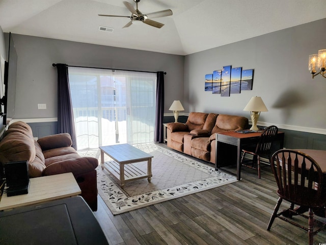 living room with vaulted ceiling, wood-type flooring, and ceiling fan with notable chandelier