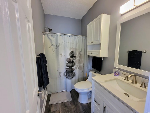 bathroom with hardwood / wood-style floors, vanity, toilet, a textured ceiling, and walk in shower