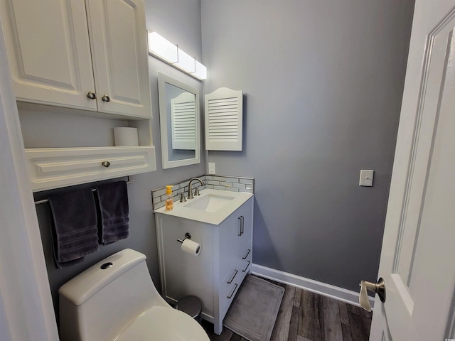 bathroom featuring wood-type flooring, vanity, and toilet