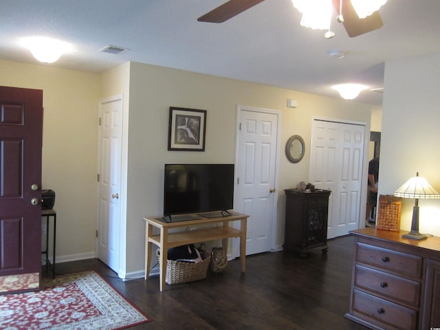 interior space featuring ceiling fan and dark wood-type flooring