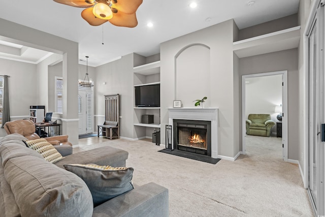 living room with light carpet, built in features, and ceiling fan