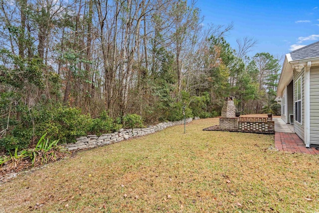 view of yard with an outdoor fireplace