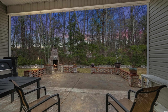 patio terrace at dusk with an outdoor brick fireplace