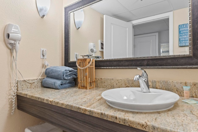 bathroom featuring vanity and a drop ceiling