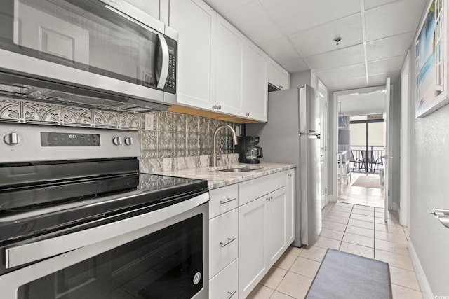 kitchen featuring backsplash, white cabinetry, sink, and appliances with stainless steel finishes