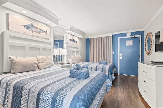 bedroom featuring dark hardwood / wood-style flooring, a textured ceiling, and crown molding