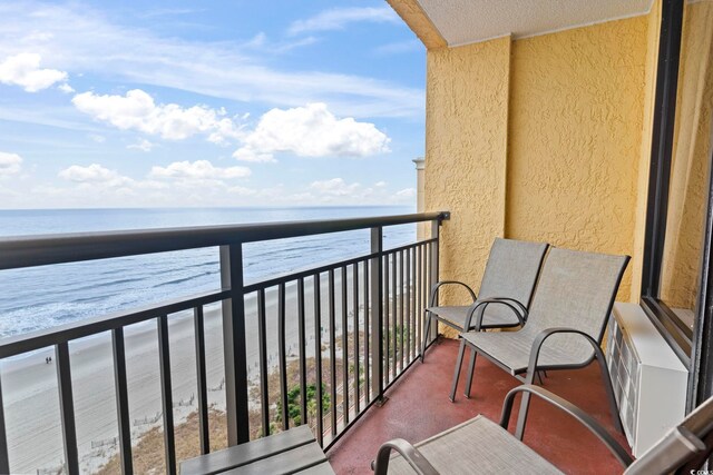 balcony with a water view and a beach view