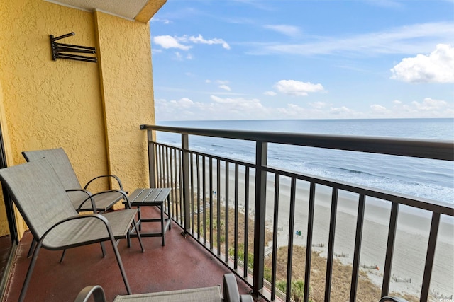 balcony with a water view and a beach view