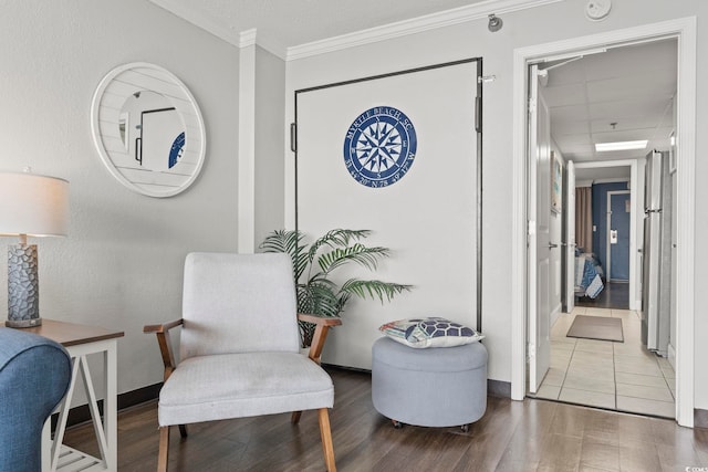 sitting room featuring crown molding and hardwood / wood-style flooring