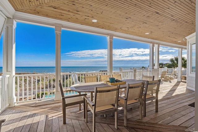 sunroom featuring a beach view, a water view, a wealth of natural light, and wood ceiling