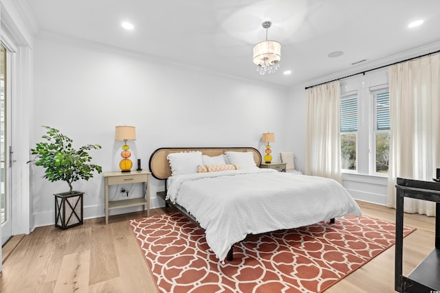 bedroom with light hardwood / wood-style floors, a notable chandelier, and ornamental molding