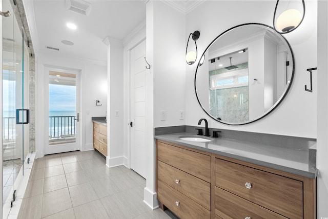 bathroom featuring vanity, a shower with door, and crown molding