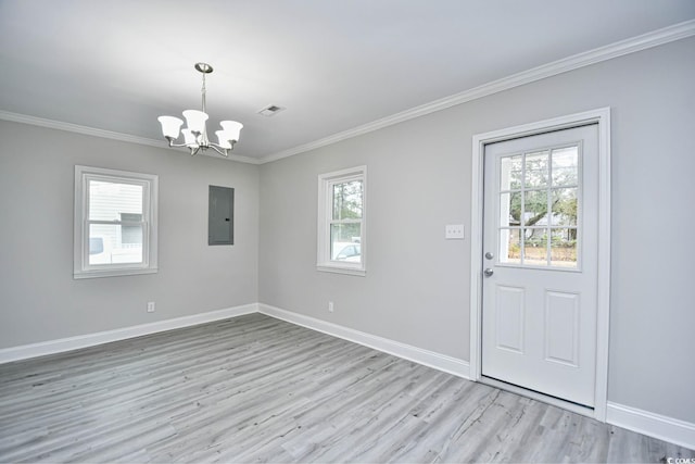 foyer with electric panel, a wealth of natural light, light hardwood / wood-style flooring, and an inviting chandelier