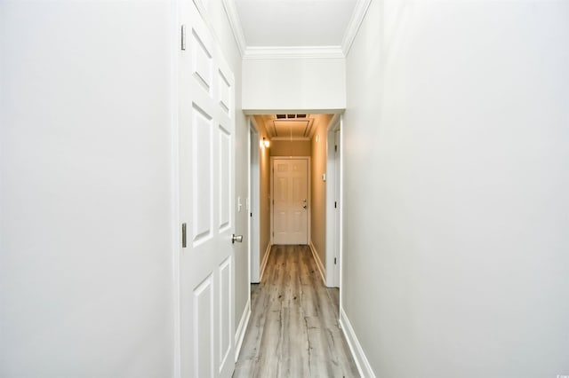 hallway with light hardwood / wood-style flooring and ornamental molding