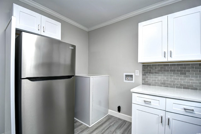 kitchen with white cabinetry, stainless steel fridge, crown molding, and light hardwood / wood-style flooring