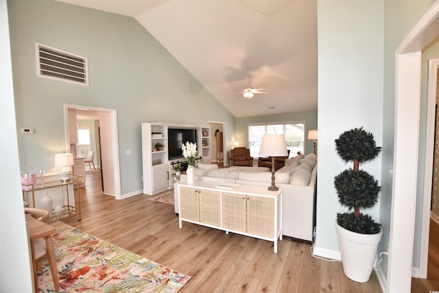 living room with ceiling fan, high vaulted ceiling, and light hardwood / wood-style flooring