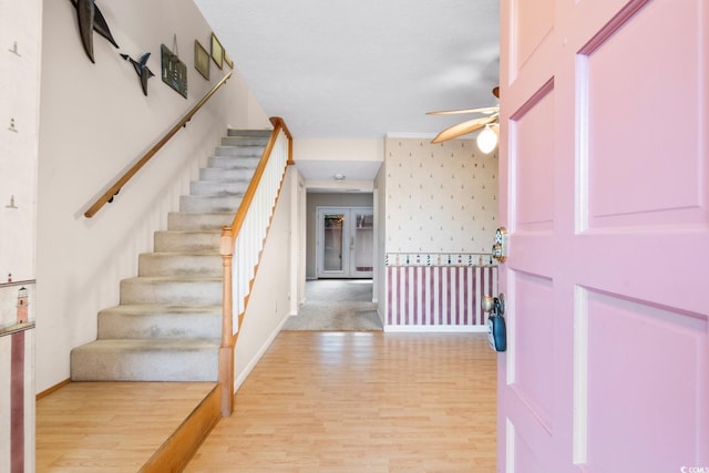 foyer entrance with ceiling fan and light hardwood / wood-style floors