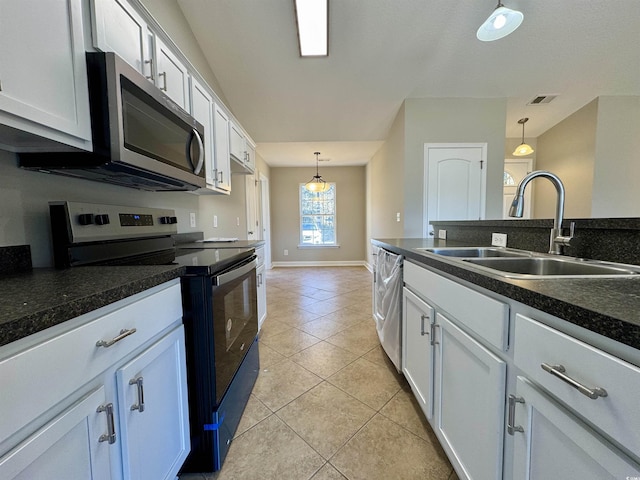 kitchen with white cabinets, appliances with stainless steel finishes, sink, and pendant lighting