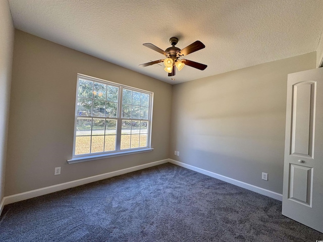 carpeted spare room with a textured ceiling and ceiling fan