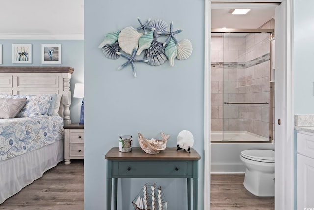 bedroom featuring ensuite bathroom and dark hardwood / wood-style floors