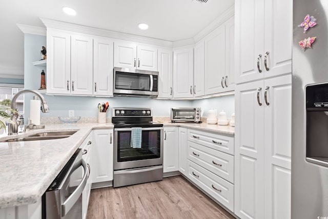 kitchen featuring white cabinets, appliances with stainless steel finishes, sink, and light hardwood / wood-style floors