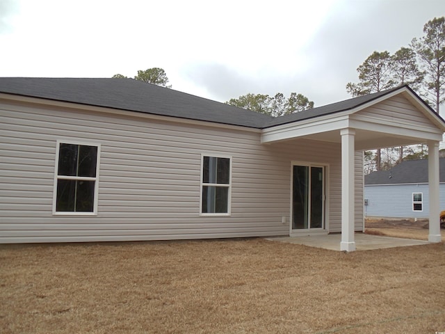 back of house with a patio and a lawn