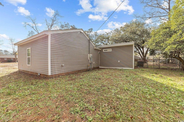 rear view of property featuring a yard and fence