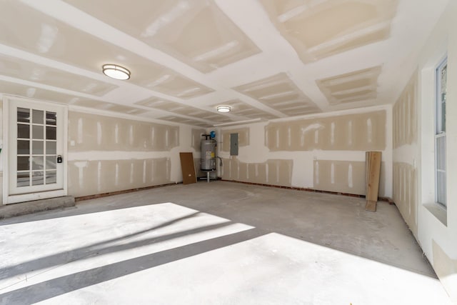 empty room featuring electric panel, water heater, and unfinished concrete floors