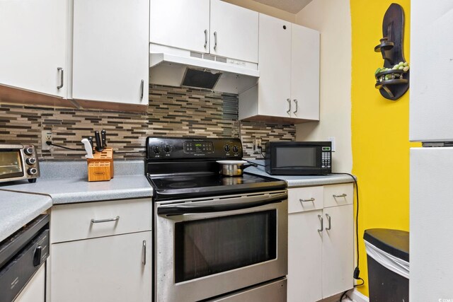 815 Rogers Dr, Myrtle Beach, SC 29577 - kitchen with stainless steel electric range, under cabinet range hood, black microwave, white cabinets, and freestanding refrigerator