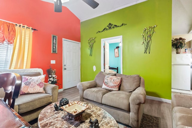 living room with hardwood / wood-style flooring, ceiling fan, and vaulted ceiling