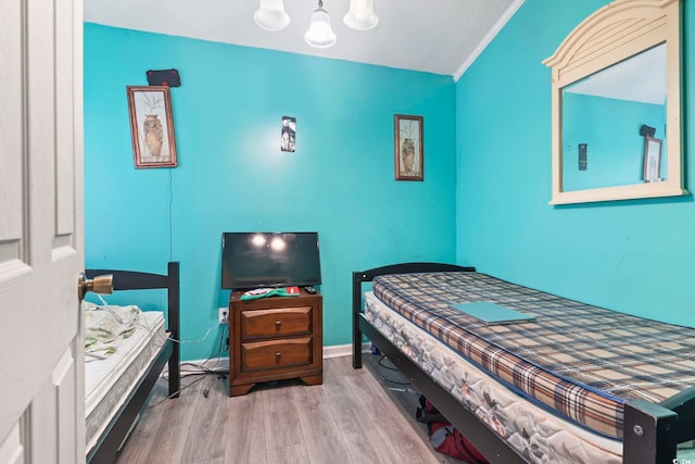 bedroom with crown molding and hardwood / wood-style floors