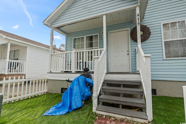 doorway to property with a lawn