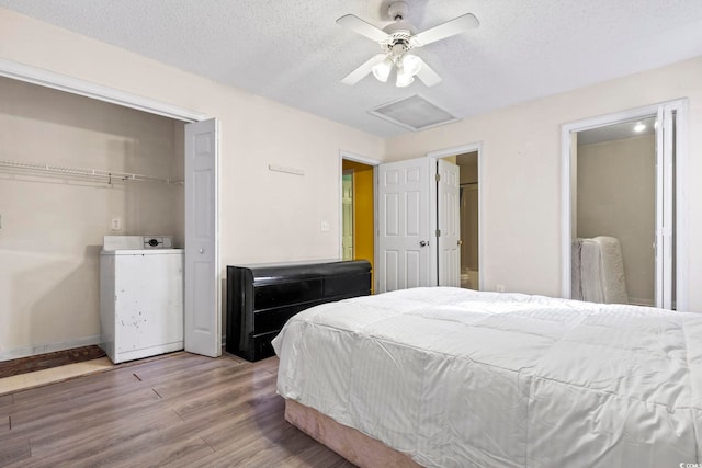 bedroom featuring washer / dryer, hardwood / wood-style floors, a textured ceiling, and ceiling fan