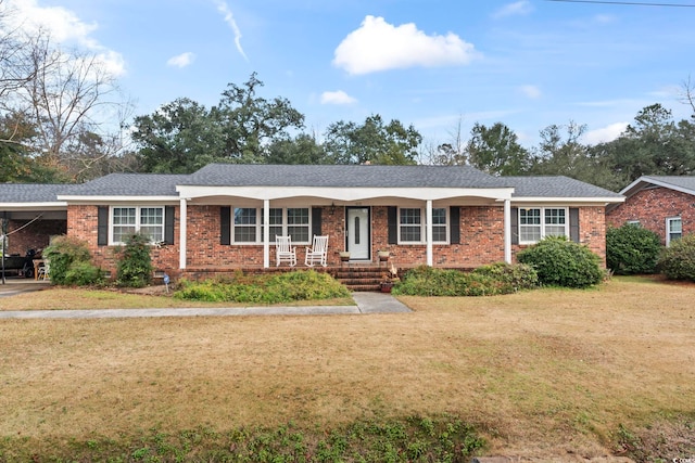 ranch-style home featuring a front yard, a carport, and covered porch