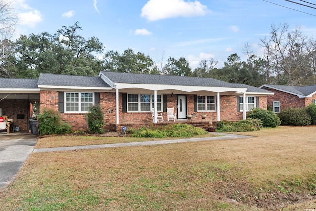 ranch-style home with covered porch, a front lawn, and a carport