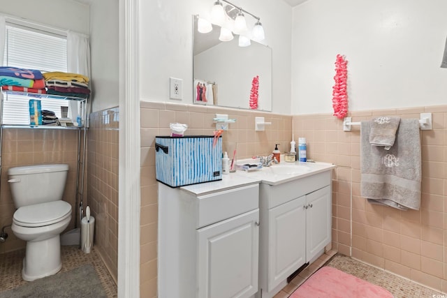 bathroom featuring tile patterned floors, vanity, tile walls, and toilet