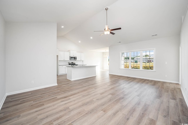 unfurnished living room with ceiling fan, sink, light hardwood / wood-style floors, and vaulted ceiling