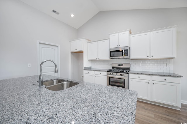 kitchen with white cabinets, light stone countertops, sink, and appliances with stainless steel finishes