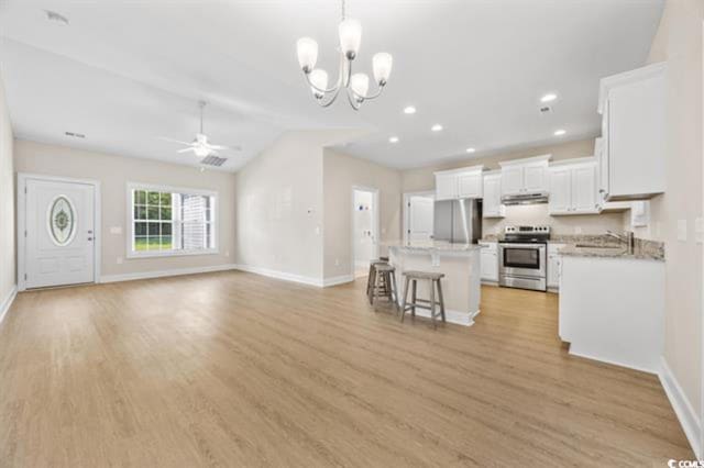 kitchen with a breakfast bar, white cabinetry, appliances with stainless steel finishes, a kitchen island, and pendant lighting