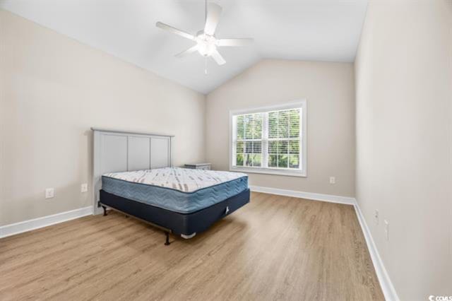 bedroom with ceiling fan, vaulted ceiling, and light hardwood / wood-style flooring