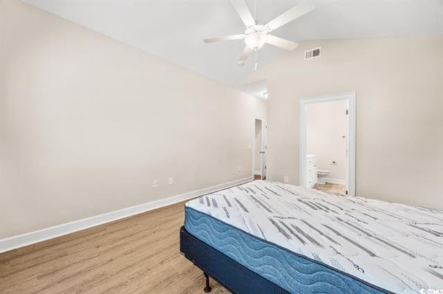 bedroom featuring ceiling fan, lofted ceiling, ensuite bathroom, and hardwood / wood-style floors