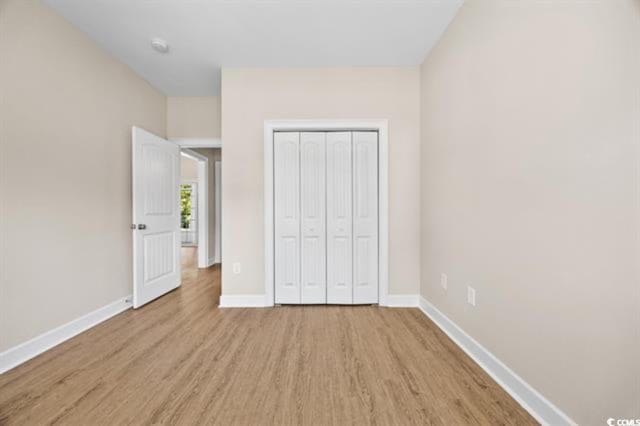 unfurnished bedroom featuring light hardwood / wood-style floors and a closet