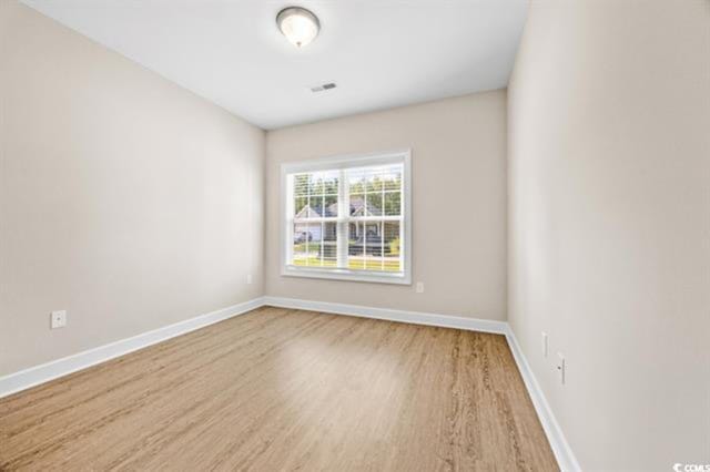 empty room with hardwood / wood-style flooring