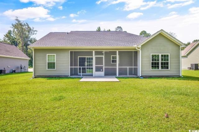 rear view of property featuring cooling unit, a yard, a patio area, and a sunroom