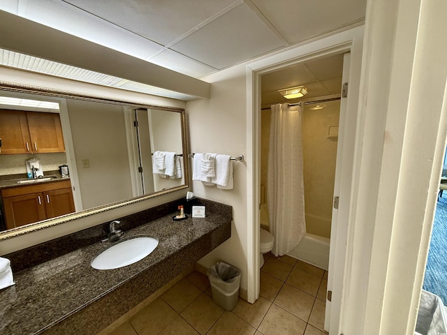 full bathroom featuring shower / tub combo, a drop ceiling, sink, tile patterned flooring, and toilet