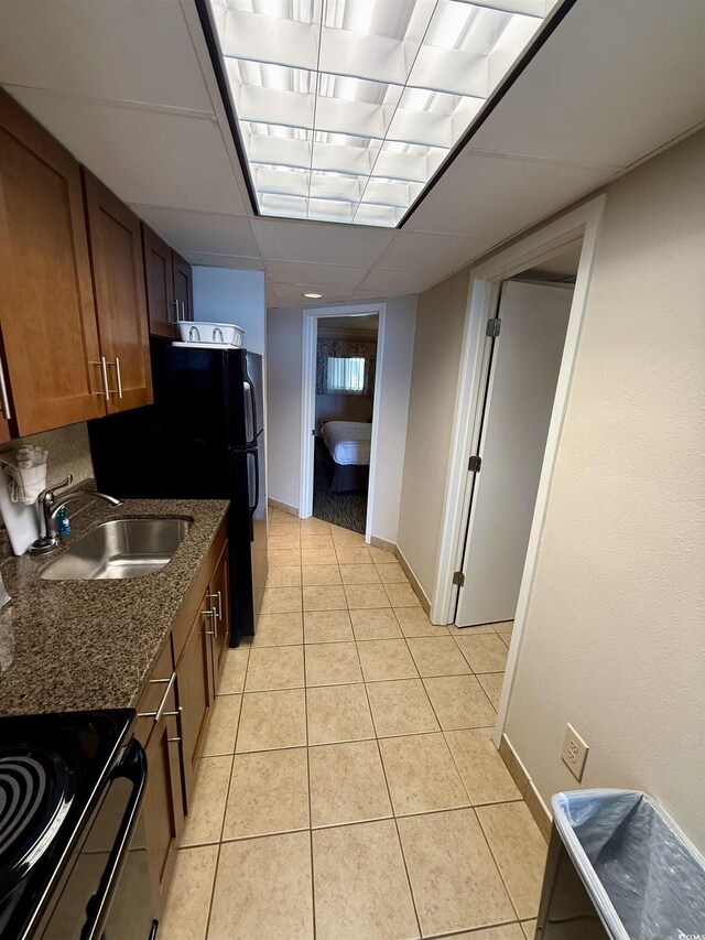 kitchen featuring light tile patterned flooring, sink, and dark stone counters