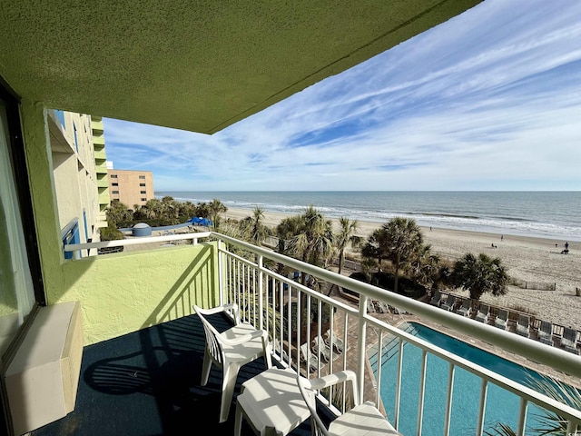 balcony featuring a water view and a view of the beach