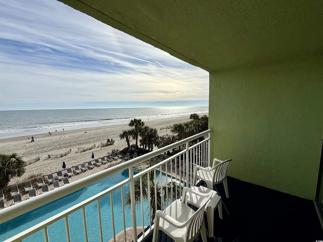 balcony with a water view and a beach view