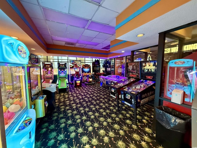 recreation room featuring carpet flooring, a raised ceiling, and a drop ceiling